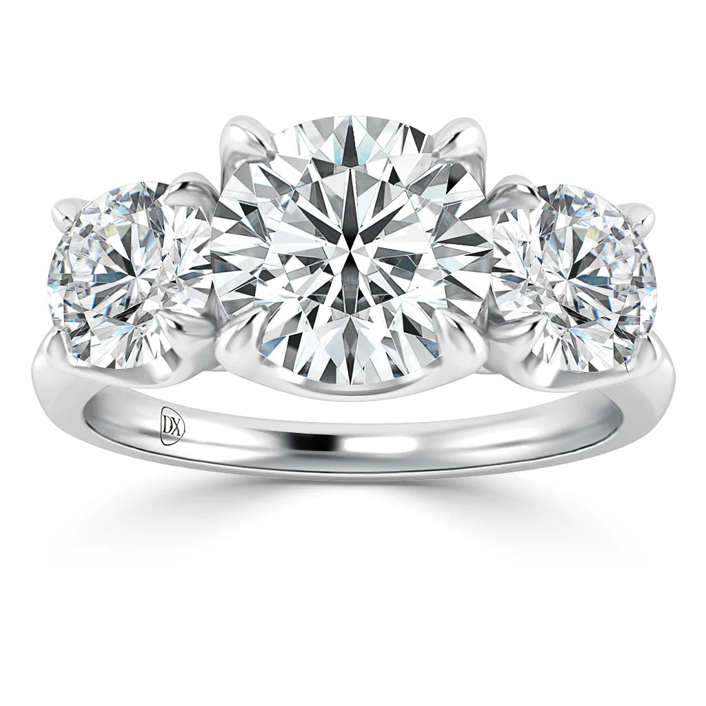 A platinum ring featuring three round brilliant-cut diamonds, with a large center stone flanked by two slightly smaller diamonds, all set in a polished, sleek band.