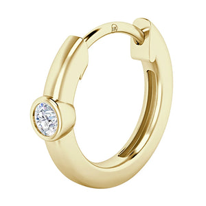 A gold hoop earring with a single round, clear gemstone set in a bezel at the front.