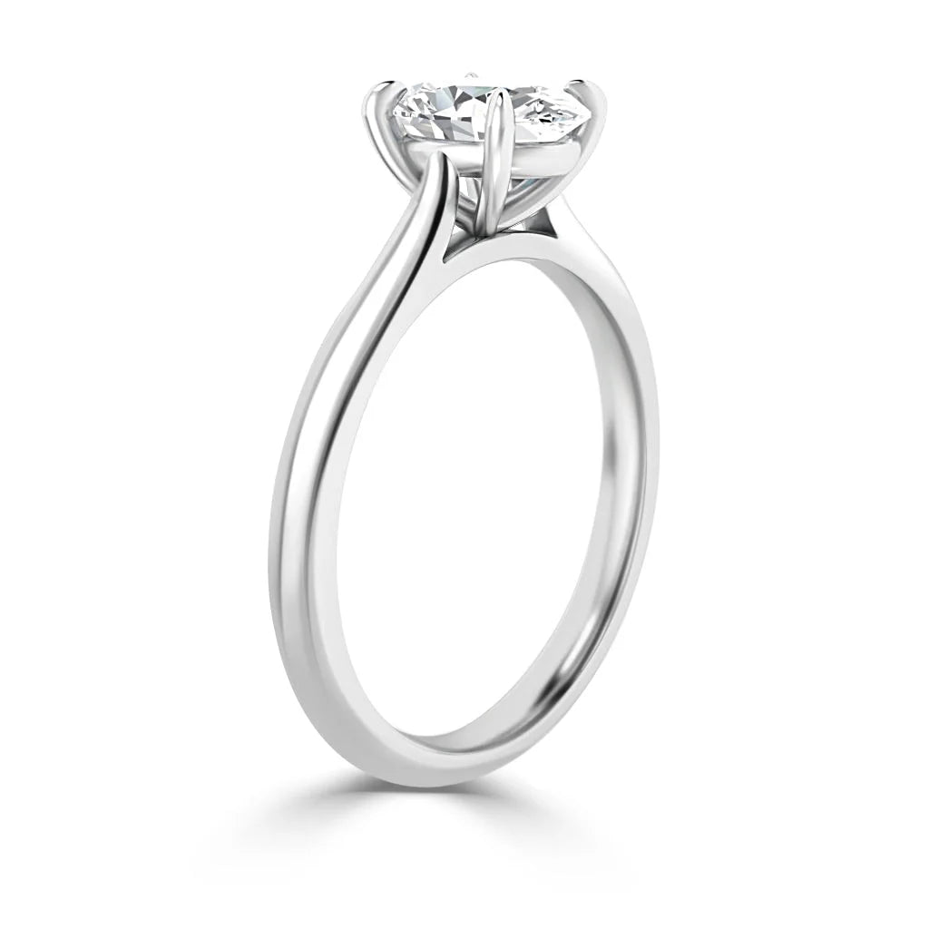 A white gold solitaire ring with a round-cut diamond set in a classic prong setting, viewed from the side.