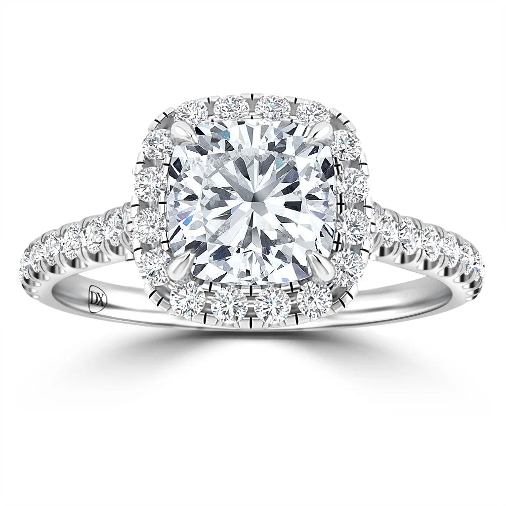 A cushion-cut diamond ring with a halo setting and a diamond-encrusted band, shown on a white background.