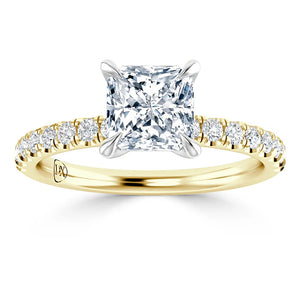 A gold ring with a square-cut diamond center and small round diamonds along the band.